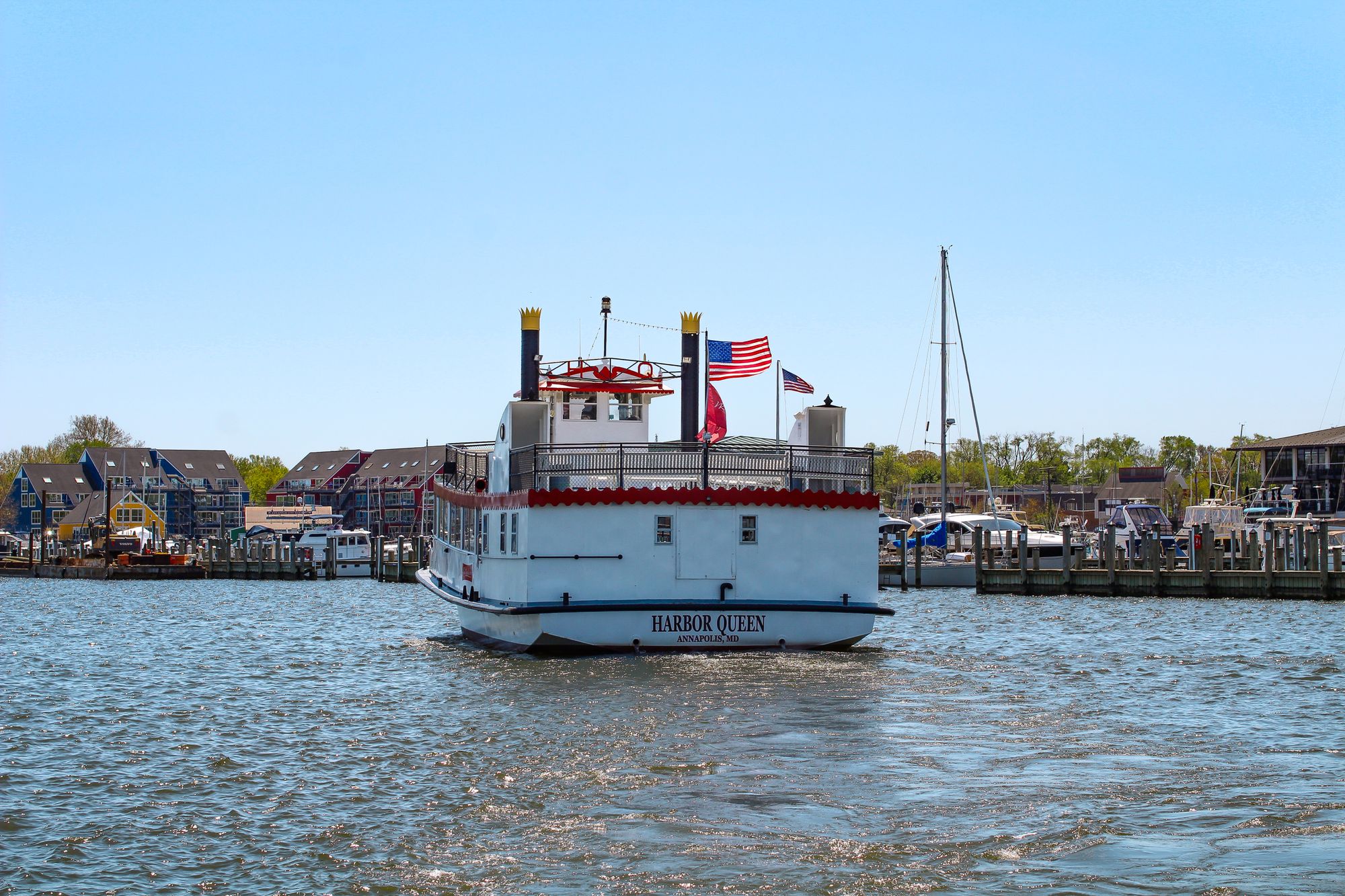 Harbor Queen tour boat at the downtown Annapolis waterfront with boats and shoreline buildings beyond.